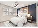 Cozy bedroom features wood accent wall, white comforter set, and lots of natural light at 6791 Navajo Ct, Denver, CO 80221