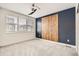 Bedroom features wood accent wall, plush carpet, and lots of natural light at 6791 Navajo Ct, Denver, CO 80221