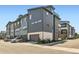 Exterior of modern townhome featuring a gray garage and tasteful landscaping at 6791 Navajo Ct, Denver, CO 80221