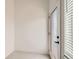 Bright hallway with tiled floors leads to a glass door with window blinds at 6791 Navajo Ct, Denver, CO 80221