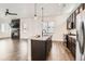 Well-lit kitchen with granite countertops, dark cabinets, and views into the living area at 6791 Navajo Ct, Denver, CO 80221