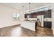 Open-concept kitchen with dark cabinetry, stainless steel appliances, and a large island at 6791 Navajo Ct, Denver, CO 80221