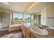 Bright bathroom features a soaking tub, glass enclosed shower, and dual sinks with natural light at 9602 Indian Wells Dr, Lone Tree, CO 80124