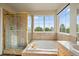 Bright bathroom features a soaking tub and glass enclosed shower with gold accents at 9602 Indian Wells Dr, Lone Tree, CO 80124