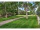 A charming pathway winds through a lush green lawn, framed by mature trees and a rustic wooden fence at 9602 Indian Wells Dr, Lone Tree, CO 80124
