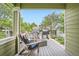 Cozy back deck is furnished with chairs, a grill, and a beautiful view of the neighborhood's greenery and other houses at 1851 S Marshall Cir, Lakewood, CO 80232