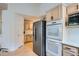 Kitchen with stainless steel appliances and light wood cabinets, complemented by wood flooring at 1851 S Marshall Cir, Lakewood, CO 80232