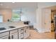 Open floor plan kitchen features countertops, cabinetry, and view of a living room with a large window at 1851 S Marshall Cir, Lakewood, CO 80232