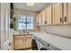 Bright laundry room features modern washer and dryer, ample cabinetry, and a sink with a window for natural light at 1851 S Marshall Cir, Lakewood, CO 80232