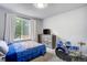 Cozy bedroom with neutral carpet, drum set, window, and view of lush greenery at 13072 Westlake Pl, Broomfield, CO 80020