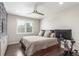 Cozy bedroom featuring hardwood floors, a ceiling fan, and a comfortable bed with built in storage at 15843 E Broncos Pl, Englewood, CO 80112