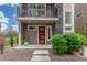 Charming home entrance features a red door, balcony, and neat landscaping at 15843 E Broncos Pl, Englewood, CO 80112