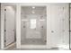 Luxurious walk-in shower with glass doors and dual shower heads in an all-white bathroom at 5693 Missoula Trl, Castle Rock, CO 80108