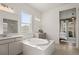 Well-lit bathroom featuring a soaking tub, double vanity, and contemporary finishes at 5693 Missoula Trl, Castle Rock, CO 80108