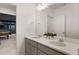Well lit bathroom features a double vanity, quartz countertops, large mirror, and an open view of a gameroom at 5693 Missoula Trl, Castle Rock, CO 80108