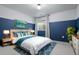 A cozy bedroom features blue and white paint, a bright window, and a plush bed with turquoise accents at 5693 Missoula Trl, Castle Rock, CO 80108