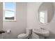 Bright powder room with a pedestal sink, toilet, and window offers a clean and functional space at 5693 Missoula Trl, Castle Rock, CO 80108