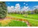 Scenic back yard with a wooden fence, green space, and mature trees at 7583 S Xanthia Ct, Centennial, CO 80112