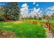 Spacious backyard features lush lawn and a rustic wood fence, and mature landscaping at 7583 S Xanthia Ct, Centennial, CO 80112