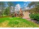 Beautiful backyard with a spacious deck and patio, a brick chimney, lush lawn and landscaping at 7583 S Xanthia Ct, Centennial, CO 80112