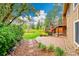 Landscaped backyard featuring a stone patio and steps leading to a raised deck, with lush lawn at 7583 S Xanthia Ct, Centennial, CO 80112