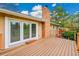 A wood deck features French doors, a brick chimney, with railings overlooking the backyard at 7583 S Xanthia Ct, Centennial, CO 80112