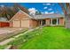 Charming brick home features a well-manicured lawn, a two-car garage, and a welcoming walkway leading to the front door at 7583 S Xanthia Ct, Centennial, CO 80112