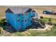 Aerial view of two-story blue house, deck, and detached garage at 8441 Flint Ridge St, Bennett, CO 80102