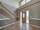 Two-story foyer with tiled floors and wooden staircase at 8441 Flint Ridge St, Bennett, CO 80102