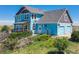 Two-story light blue house with brown accents, attached garage, and deck at 8441 Flint Ridge St, Bennett, CO 80102