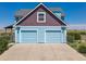 Two-car attached garage with light blue exterior and driveway at 8441 Flint Ridge St, Bennett, CO 80102