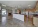 Open kitchen with island, stainless steel appliances, and tile floor at 8441 Flint Ridge St, Bennett, CO 80102