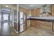 Modern kitchen with stainless steel refrigerator and wood cabinets at 8441 Flint Ridge St, Bennett, CO 80102