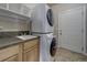 Laundry room with washer, dryer, sink, and additional storage at 8441 Flint Ridge St, Bennett, CO 80102