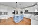 Bright kitchen features white cabinets, stainless steel appliances, a blue island, and hardwood floors at 17826 E Cloudberry Dr, Parker, CO 80134