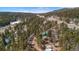 An aerial shot shows the house close to a road and nestled between the area's trees at 27231 Log Trl, Conifer, CO 80433