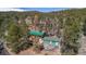An aerial view presents a house with a green roof next to a three-car garage at 27231 Log Trl, Conifer, CO 80433