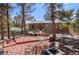Back deck showcasing dining and seating areas with home surrounded by mature trees and foliage at 27231 Log Trl, Conifer, CO 80433
