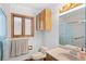 Bathroom featuring glass shower, framed window and single sink vanity at 27231 Log Trl, Conifer, CO 80433