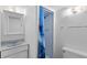 Bright bathroom featuring a sink with a medicine cabinet and a walk-in shower with a blue shower curtain at 27231 Log Trl, Conifer, CO 80433
