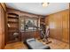 Spacious exercise room with wall to wall wood shelves and a large window at 27231 Log Trl, Conifer, CO 80433