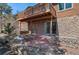Charming home exterior with a wooden deck, stone accents, a brick patio, and natural landscaping at 27231 Log Trl, Conifer, CO 80433