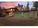Charming house featuring a balcony, log siding, stone details and a two-car garage, set against a colorful sky at 27231 Log Trl, Conifer, CO 80433