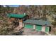 Stunning exterior view of a log home with a green metal roof and a two-car garage, nestled among mature trees at 27231 Log Trl, Conifer, CO 80433