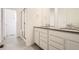 Well-lit bathroom featuring double vanity, glass shower and tile flooring at 537 Nightsky St, Erie, CO 80516