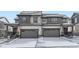 Two-story townhome showcasing attached garages, dark trim, and solar panels at 537 Nightsky St, Erie, CO 80516