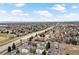 Expansive aerial view showcases the neighborhood's layout, nearby highway, and distant city skyline at 7770 W 87Th Dr # F, Arvada, CO 80005