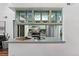 Kitchen with stainless steel appliances, open shelving, green cabinets, and stylish countertops and backsplash at 7770 W 87Th Dr # F, Arvada, CO 80005