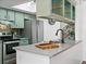 Well-lit kitchen featuring stainless steel appliances, light green cabinets, and stylish backsplash and countertop at 7770 W 87Th Dr # F, Arvada, CO 80005