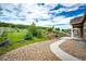 Landscaped backyard featuring a stone path, white fencing, and diverse plantings, offering privacy and scenic beauty at 3855 Old Oaks St, Castle Rock, CO 80104